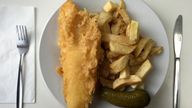 A plate of traditional fish and chips with a gherkin on a table in a seafront fish and chip shop in Brighton, Britain, December 22, 2015. REUTERS/Russell Boyce/File Photo