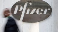 A man walks past Pfizer's world headquarters in New York April 28, 2014.