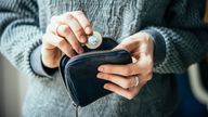 Hands holding british pound coin and small money pouch