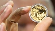 Reserve Bank of Zimbabwe Governor, John Mangudya holds a sample of a gold coin at the launch in Harare, Monday, July, 25, 2022. Pic: AP