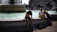 People cool off by a water fountain during a heatwave, at Trafalgar Square in London, Britain, July 19, 2022. REUTERS/Henry Nicholls
