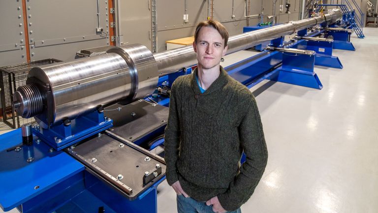 Dr Nick Hawker, chief executive of First Light Fusion, standing in front of the UK's largest hyper-velocity gas gun. Pic: 