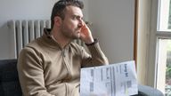 Shocked man reading some bills energy expenses on sofa living room