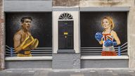 People walking past a mural on Hill Street in Belfast by Ciaran Gallagher Art, commissioned by local bar owner Willie Jack, showing conservative party candidates, Rishi Sunak and Liz Truss as two boxers about to fight it out to be the UK Prime Minister. Picture date: Tuesday August 16, 2022.
