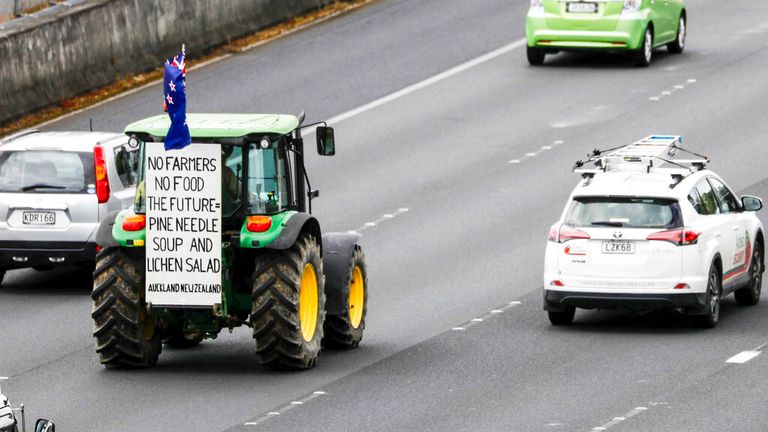 A tractor drives down the southern motorway in central Auckland during a protest on climate change proposals to make New Zealand farmers pay for greenhouse gas emissions, Thursday, Oct. 20, 2022. New Zealand farmers drove their tractors to towns around New Zealand on Thursday in protest at a proposed new tax on cow burps and other farm greenhouse gas emissions. (Dean Purcell/New Zealand Herald via AP)