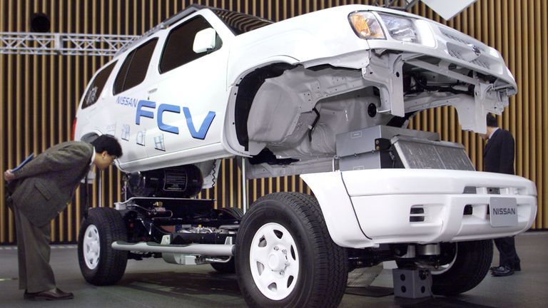 A man looks at Nissan Motor Co's prototype fuel cell car Nissan FCV on display in Tokyo January 28, 2002. Nissan's ultimate environment-friendly clean car, running on hydrogen with speeds of up to 120km/hour, is expected to be a part of test runs around fall of 2002 with hopes to go on the market in 2005, the carmaker said.