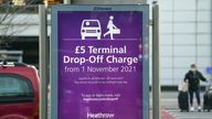 Passengers walk past an information sign at Terminal 3 of Heathrow Airport, London, advising of the new drop-off charge for people transporting travellers to the airport by vehicle. Picture date: Monday November 8, 2021.