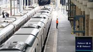 A member of staff signals to a train at King's Cross railway station in London. Rail services have been severely disrupted as members of the Transport Salaried Staffs Association (TSSA) and the Rail, Maritime and Transport (RMT) union strike in a continuing row over pay, jobs and conditions. Picture date: Saturday August 20, 2022.