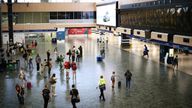 People look at departure information screens at Euston railway station, as railway workers strike over pay and terms