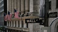 People walk by the New York Stock Exchange (NYSE) in an empty Financial District on June 15, 2020 in New York City. 