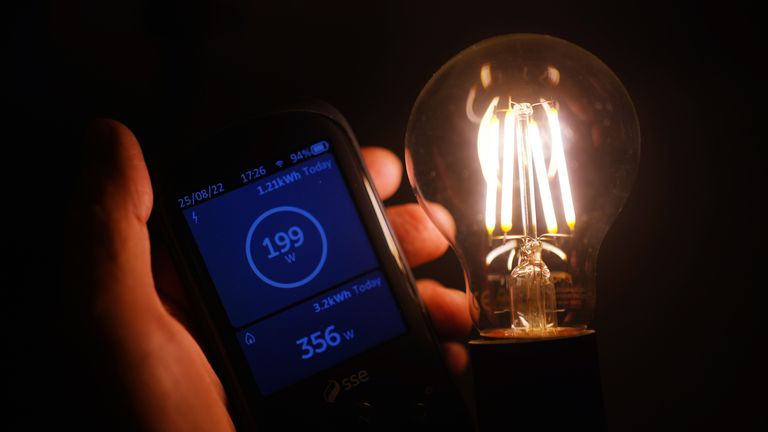 A handheld SSE smart meter for household energy usage is held next to an energy-efficient LED light bulb. Families across Great Britain will find out on Friday how tough energy bills will be this winter but they may have to wait to discover what the Government will do to help Picture date: Thursday August 25, 2022.

