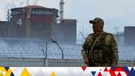 A serviceman with a Russian flag on his uniform stands guard near the Zaporizhzhia nuclear power plant on 4 August