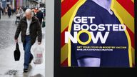 A man walks past an advertising board encouraging people to get their booster vaccination, amid the coronavirus disease (COVID-19) outbreak in Liverpool, Britain, December 29, 2021. REUTERS/Phil Noble