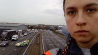 Handout photo issued by Just Stop Oil of a protester who has climbed a gantry on the M25 between junctions six and seven in Surrey, leading to the closure of the motorway. Surrey Police said the decision was made to close the road "for the safety of everyone" while officers attempt to remove the activist. Picture date: Monday November 7, 2022.