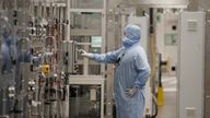 A worker in a protective suit operates a machine inside the Envision battery manufacturing plant at Nissan's Sunderland factory, Britain, July 1, 2021. REUTERS/Phil Noble
