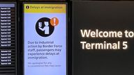 An arrivals board displays a message warning users of terminal 5 about industrial action by Border Force staff, at Heathrow Airport, near London, Britain, December 23, 2022. REUTERS/Peter Nicholls
