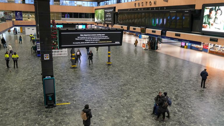 People wait beneath information screens displaying train times at Euston Station during industrial action in London, Britain December 28, 2022. REUTERS/Maja Smiejkowska
