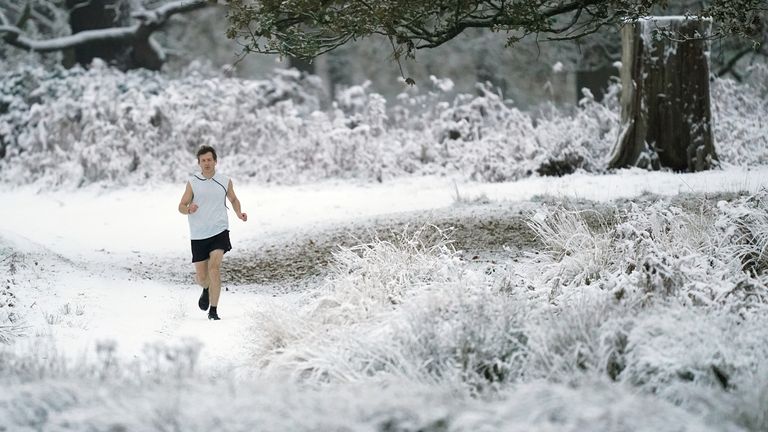 A person jogging in Richmond Park in south west London. Snow and ice have swept across parts of the UK, with cold wintry conditions set to continue for days. Picture date: Monday December 12, 2022.