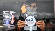 The chancellor Rishi Sunak placing an Eat Out to Help Out sticker in the window of a business