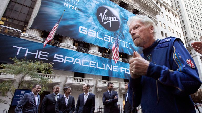 FILE - In this Monday, Oct. 28, 2019 file photo, Richard Branson, right, founder of Virgin Galactic, and company executives gather for photos outside the New York Stock Exchange before his company's IPO. Branson announced Thursday, July 1, 2021 he plans to fly into space this month on the next test flight of his Virgin Galactic rocket ship. The launch window will open July 11. (AP Photo/Richard Drew, File)