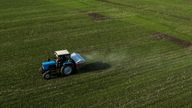 An aerial view shows a tractor spreading fertiliser on a wheat field near the village of Yakovlivka after it was hit by an aerial bombardment outside Kharkiv, as Russia's attack on Ukraine continues, April 5, 2022.