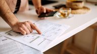 Unrecognisable man using calculator on the phone to calculate expenses