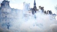 Masked protesters react amid tear gas during clashes at a demonstration as part of the 12th day of nationwide strikes and protests against French government's pension reform, in Paris, France, April 13, 2023. REUTERS/Stephane Mahe
