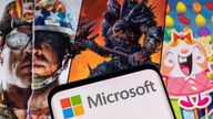 Microsoft logo is seen on a smartphone placed on displayed Activision Blizzard's games characters