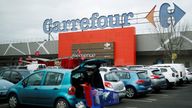 A customer empties his trolley in front of a Carrefour hypermarket store in Carquefou near Nantes, France January 13, 2021