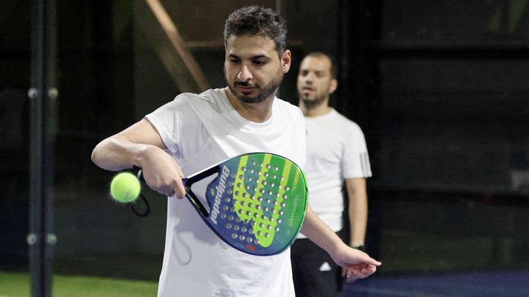 A man plays paddle tennis