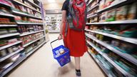 A shopper walking through the aisle of a Tesco supermarket