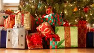 Presents under the Christmas tree in a home setting.