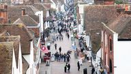 A cold winter day in famous tourist destination Canterbury in England. The city centre is crowded with tourists and locals despite the chilly weather. The medieval architecture and houses are much in evidence from the elevated viewpoint. Pubs and fast-food restaurants line the historic main street of Canterbury, Kent England.