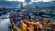 A container is loaded onto a cargo ship in the harbor in Frankfurt, Germany, Wednesday, Dec. 13, 2023. In background the European Central Bank. (AP Photo/Michael Probst)