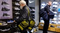 FILE PHOTO: A shopper carrying JD Sports bags looks at footwear at a JD Sports store in London, Britain. Picture taken November 17, 2021. REUTERS/May James/File Photo