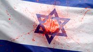 An Israeli flag splashed with red paint is displayed during a pro-Palestinian protest. Pic: Reuters