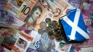 File photo dated 09/04/18 of coins and Scottish bank notes. Employed Scots have been urged to check if they are eligible for benefits. As 2024 begins, Social Justice Secretary Shirley-Anne Somerville said those in work are able to claim some parts of social security administered by the Scottish Government. Issue date: Monday January 8, 2024.