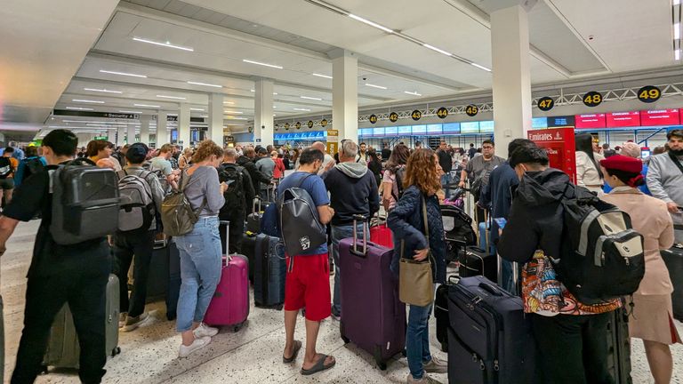 Passengers queue at the airport following a power cut. Pic: Chris Shaw/Reuters