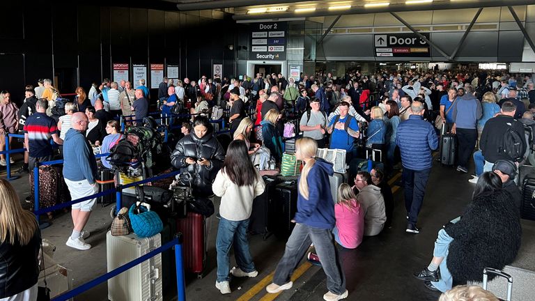 Passengers queue outside Terminal 1. Pic: Reuters