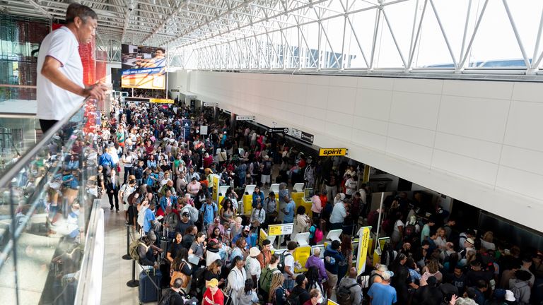 Travelers wait in line at Baltimore/Washington International Thurgood Marshall Airport in Baltimore, Friday, July 19, 2024. (AP Photo/Stephanie Scarbrough)