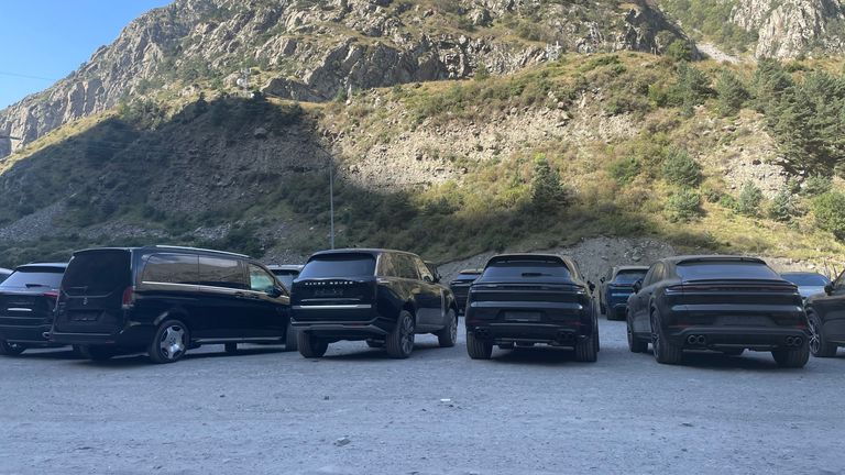 Makeshift car park full of luxury cars near the border