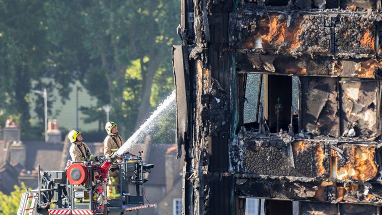 Firefighters continue to dampen down the tower block following the deadly blaze