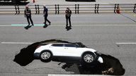 A vehicle that fell into a sinkhole is seen on a street in Seoul, South Korea.
Pic:Yonhap/AP