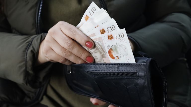 A woman holding sterling bills in her wallet. Pic: iStock