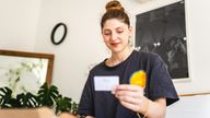 A woman pretends she's delighted to receive a gift card. Pic: iStock