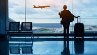 Silhouette of passenger in airport watching aircraft taking off