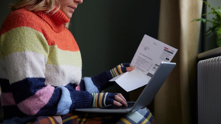 A file picture of a woman looking at her energy bills while trying to stay warm. Pic: iStock