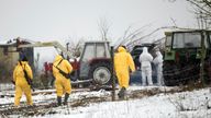 Staff in PPE with rifles at a farm in Hoppegarten, east of Berlin. Pic: AP