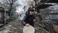 A woman walks past debris in the aftermath of Russian shelling, in Mariupol, Ukraine in 2022. Pic: AP